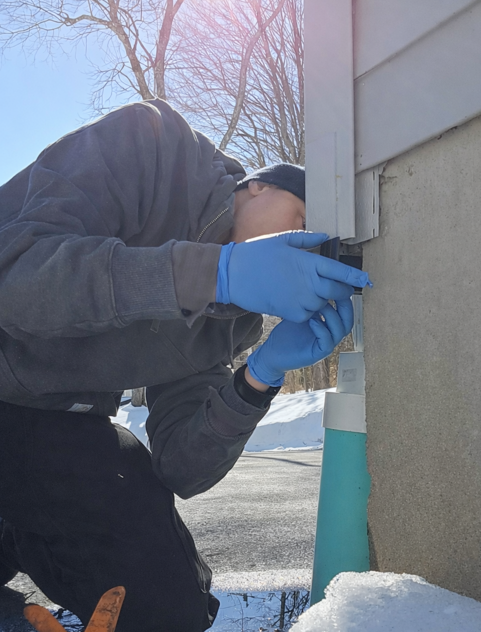 Ransford technician installing a corner cap into a vinyl siding corner